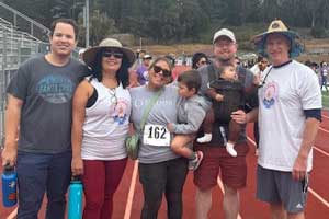 Group of people standing together outdoors on a track at a community walk-run event.