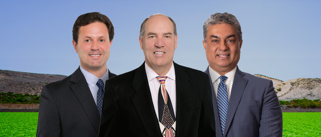 Bankers standing in front of a field of crops.